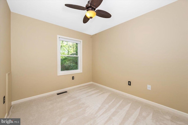 unfurnished room with baseboards, a ceiling fan, light colored carpet, and visible vents