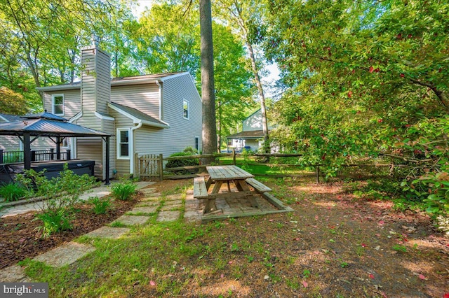 view of yard with a gazebo, a hot tub, and fence