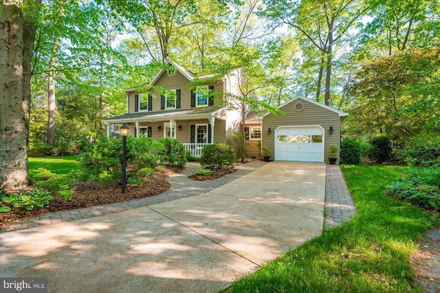 colonial-style house featuring a porch, a garage, and driveway