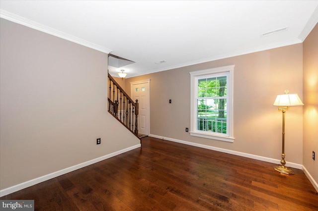 empty room with crown molding, baseboards, stairs, and wood finished floors