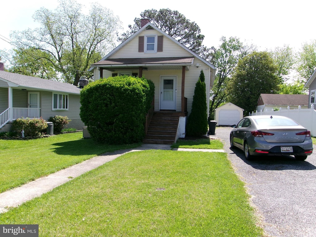 8807 Fearne Ave, Baltimore, MD 21234 - bungalow-style home with an outbuilding, a detached garage, a front yard, and a chimney
