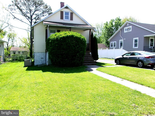 8807 Fearne Ave, Baltimore, MD 21234 - view of front of house with fence, a chimney, and a front yard