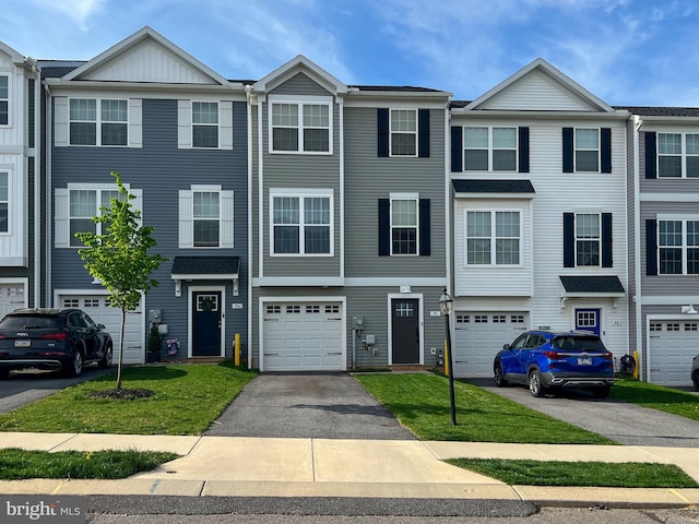 townhome / multi-family property featuring driveway and a garage
