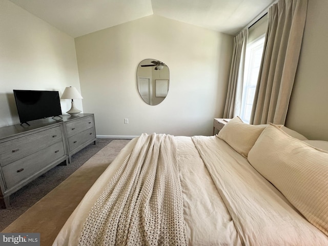 bedroom with carpet flooring, baseboards, and lofted ceiling