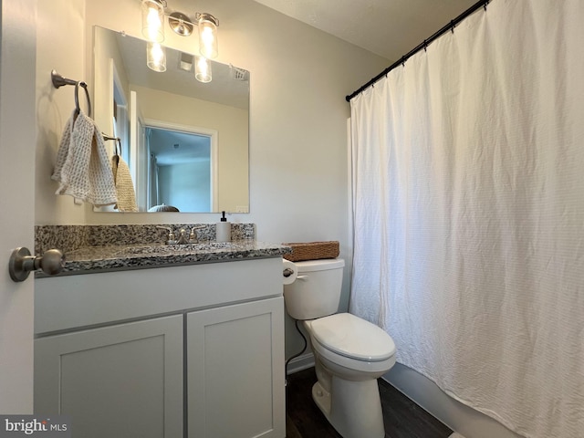 bathroom with toilet, wood finished floors, and vanity