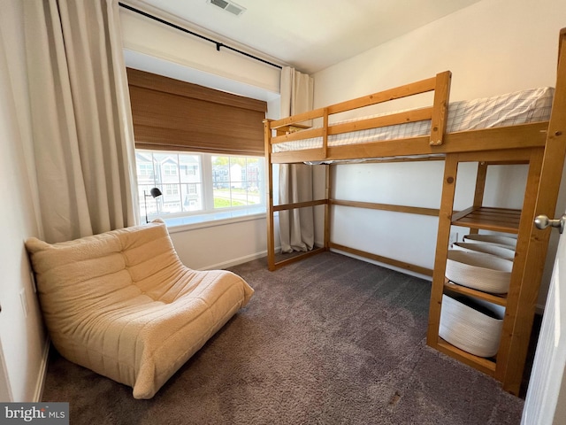 bedroom with baseboards, dark colored carpet, and visible vents