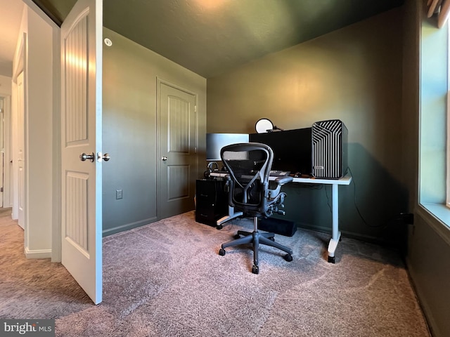 carpeted home office with baseboards and vaulted ceiling