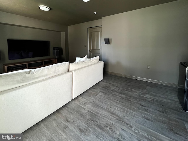 living area with baseboards and wood finished floors