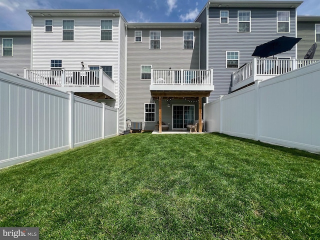 rear view of house featuring a lawn, central AC, and fence