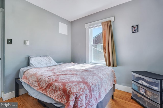 bedroom featuring baseboards and wood finished floors
