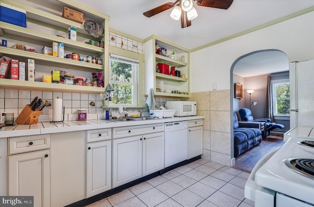 kitchen with open shelves, a sink, white appliances, arched walkways, and a ceiling fan