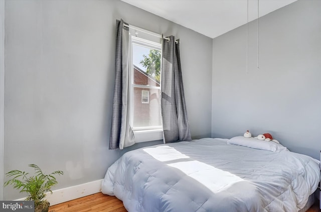 bedroom featuring baseboards and wood finished floors