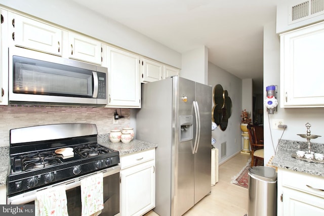 4024 Nicholas Ct, Fairfax, VA 22033 - kitchen with stainless steel appliances, light wood-type flooring, white cabinetry, tasteful backsplash, and light stone countertops