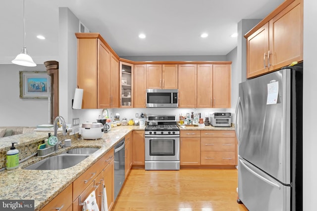 20920 Houseman Ter, Ashburn, VA 20148 - kitchen with light stone countertops, glass insert cabinets, light wood-style floors, a sink, and stainless steel appliances