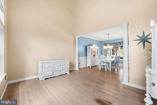 dining space with an inviting chandelier, ornamental molding, a high ceiling, and wood finished floors