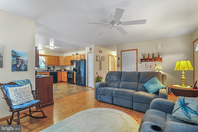 living room with light wood-style floors, ceiling fan, and visible vents