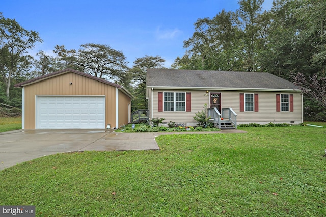view of front facade featuring a detached garage, an outbuilding, and a front yard