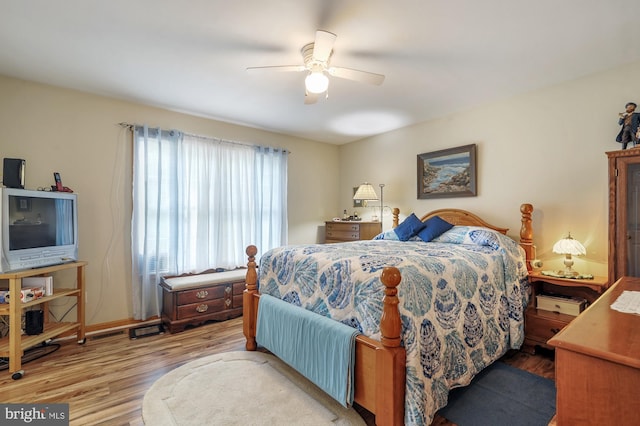 bedroom featuring a ceiling fan, baseboards, and wood finished floors