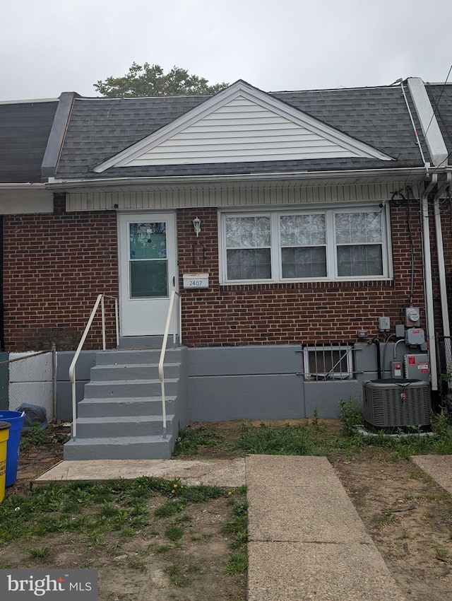 2407 S 12th St, Camden, NJ 08104 - view of front of home with a shingled roof, brick siding, and central AC