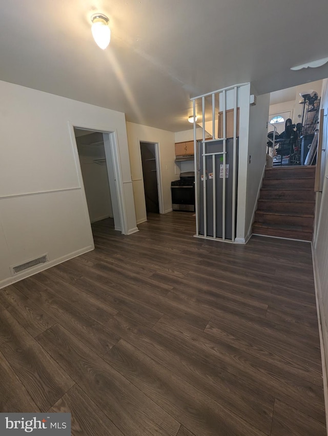 2407 S 12th St, Camden, NJ 08104 - unfurnished living room with dark wood finished floors, visible vents, baseboards, and stairway