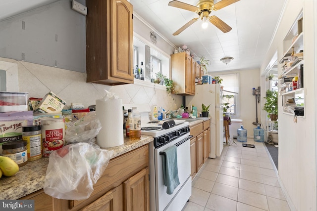 kitchen featuring a sink, white appliances, a ceiling fan, light tile patterned floors, and tasteful backsplash