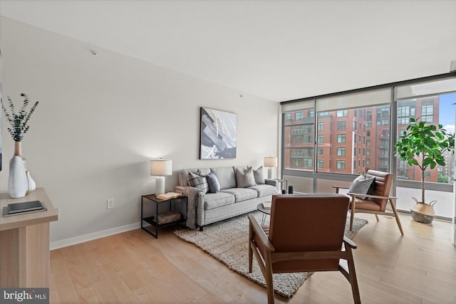 living area with baseboards, floor to ceiling windows, and light wood-style floors