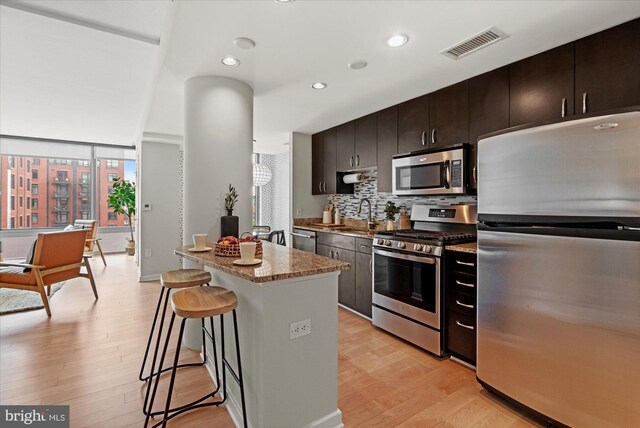 475 K St NW Unit 817, Washington, DC 20001 - kitchen featuring appliances with stainless steel finishes, a kitchen bar, light wood-style flooring, and visible vents