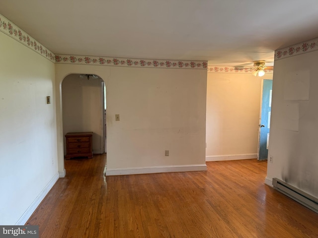 8600 Gue Rd, Damascus, MD 20872 - unfurnished room with a ceiling fan, a baseboard radiator, baseboards, wood finished floors, and arched walkways