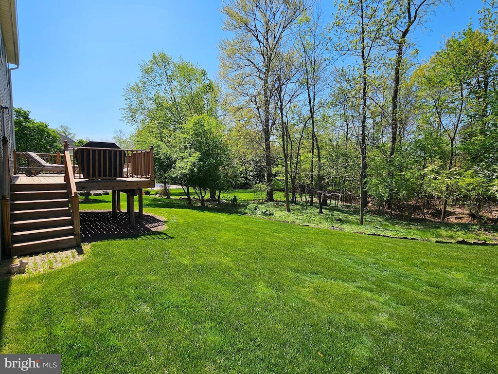 view of yard with a wooden deck and stairway
