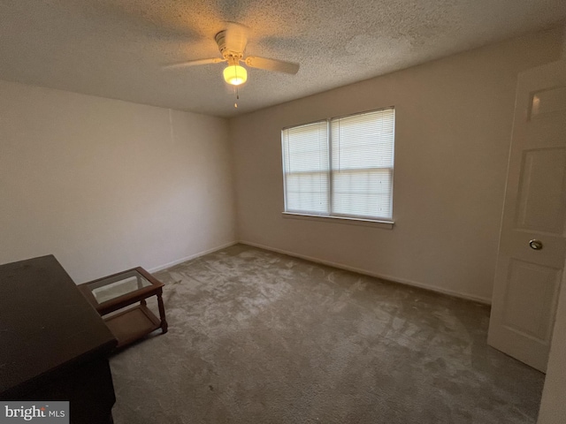 interior space with a ceiling fan, baseboards, and a textured ceiling