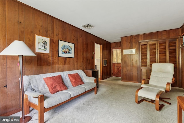 living area with light carpet, wood walls, and visible vents