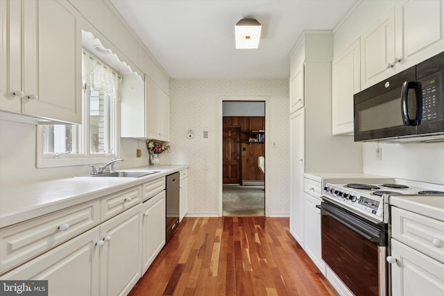 kitchen with stainless steel dishwasher, black microwave, wallpapered walls, electric range oven, and a sink