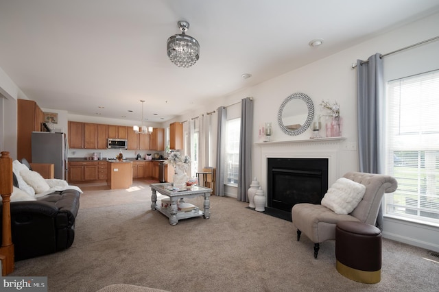 57 Pebble Creek Dr, Smyrna, DE 19977 - living room with light carpet, a chandelier, and a fireplace with flush hearth