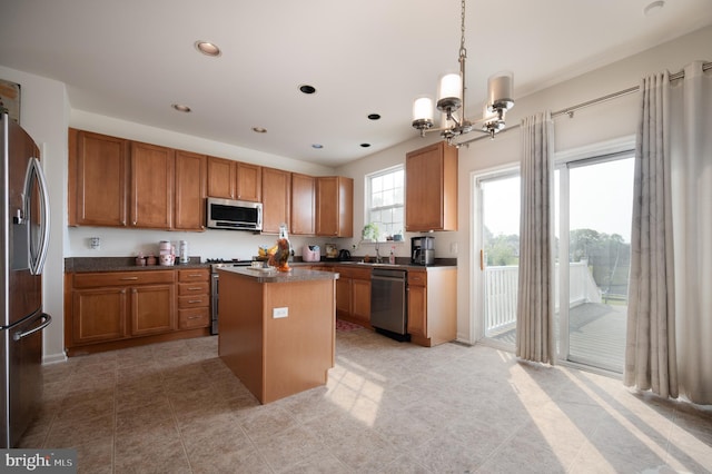 57 Pebble Creek Dr, Smyrna, DE 19977 - kitchen with appliances with stainless steel finishes, brown cabinetry, a chandelier, a center island, and dark countertops