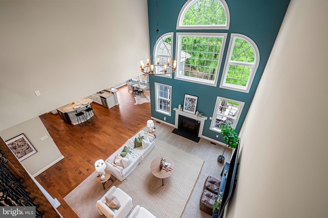 6354 Islington St, Middle River, MD 21220 - living area with a high ceiling, a fireplace with flush hearth, wood finished floors, and a chandelier