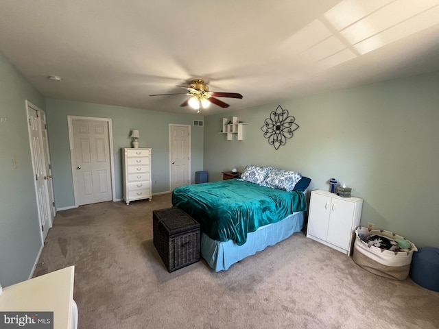 carpeted bedroom with ceiling fan, visible vents, and baseboards