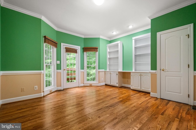 12850 Salmon Run Ct, Manassas, VA 20112 - interior space with baseboards, built in study area, built in shelves, crown molding, and light wood-type flooring