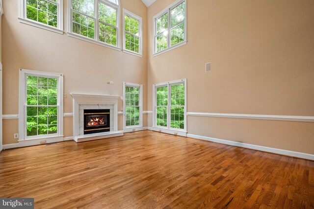 12850 Salmon Run Ct, Manassas, VA 20112 - unfurnished living room with a premium fireplace, wood finished floors, baseboards, and a high ceiling