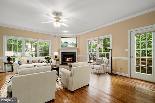 12850 Salmon Run Ct, Manassas, VA 20112 - living area featuring baseboards, a glass covered fireplace, ceiling fan, crown molding, and wood finished floors