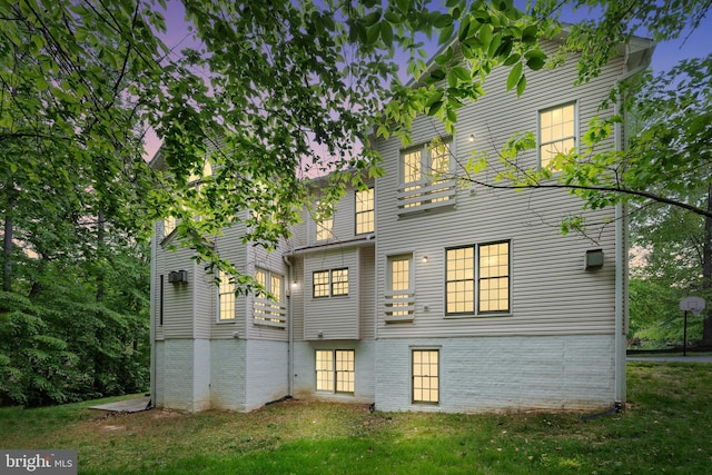 12850 Salmon Run Ct, Manassas, VA 20112 - back of house at dusk with a balcony and a lawn