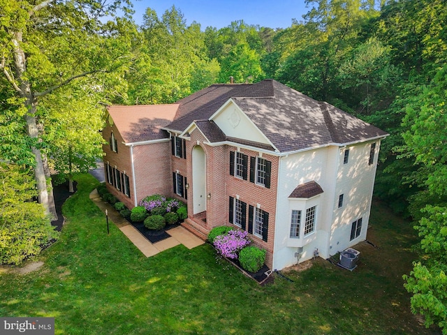 12850 Salmon Run Ct, Manassas, VA 20112 - view of front of home with a view of trees, central air condition unit, a front yard, brick siding, and roof with shingles
