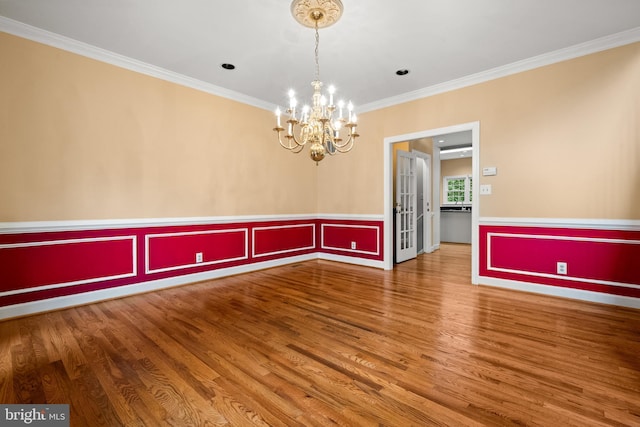 12850 Salmon Run Ct, Manassas, VA 20112 - spare room with a decorative wall, a wainscoted wall, wood finished floors, ornamental molding, and a chandelier