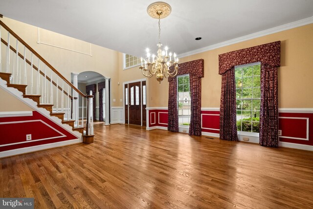 12850 Salmon Run Ct, Manassas, VA 20112 - foyer entrance with arched walkways, a notable chandelier, crown molding, and wood finished floors