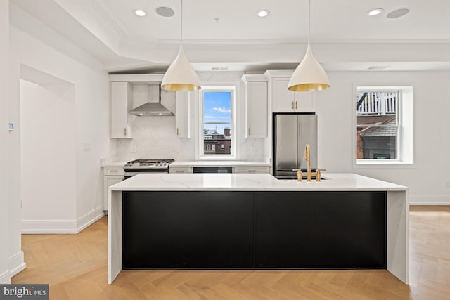 kitchen with crown molding, white cabinets, a sink, wall chimney exhaust hood, and stainless steel appliances
