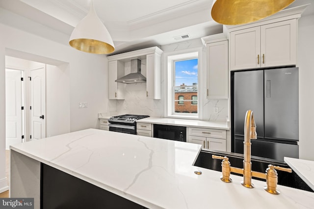 kitchen featuring backsplash, white cabinets, ornamental molding, stainless steel appliances, and wall chimney exhaust hood