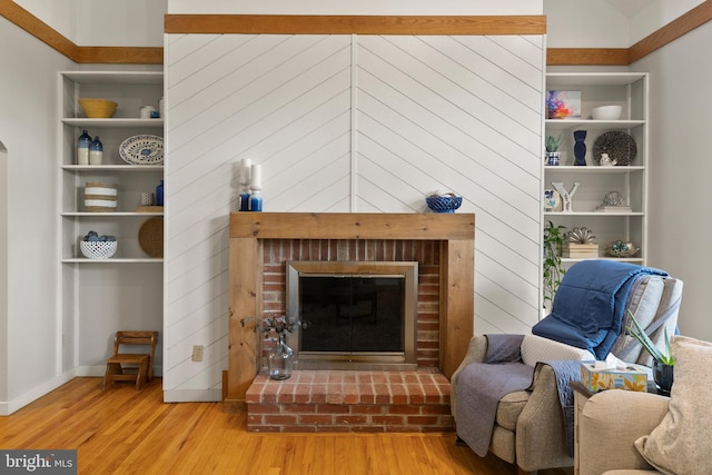 living room with baseboards, a fireplace, and wood finished floors