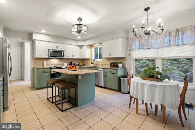 kitchen with green cabinetry, a notable chandelier, white cabinetry, and stainless steel appliances