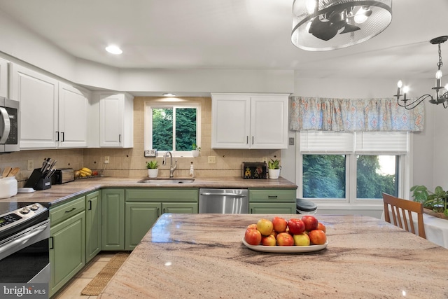 kitchen featuring a sink, green cabinetry, stainless steel appliances, and white cabinets