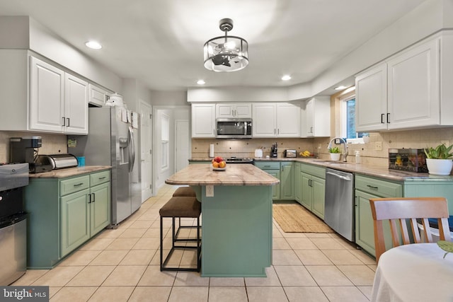 kitchen with white cabinets, green cabinets, and stainless steel appliances