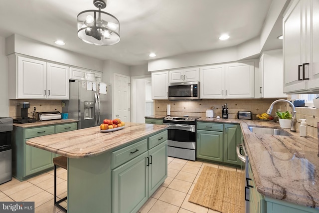 kitchen featuring a sink, green cabinetry, appliances with stainless steel finishes, and white cabinets